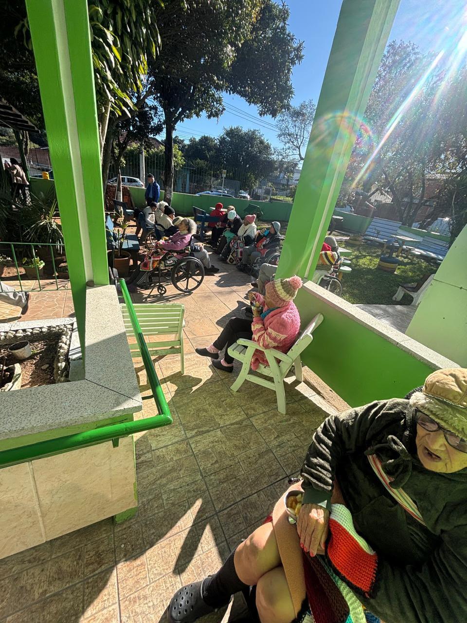 Idosos sentados no pátio ensolarado da casa